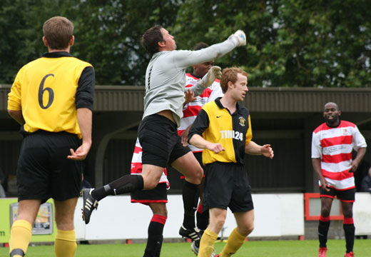 Goalkeeper Craig Stoner punches clear from Phil Williams
