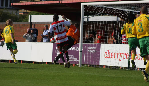 Visiting goalkeeper makes a save as Phil Williams looks on