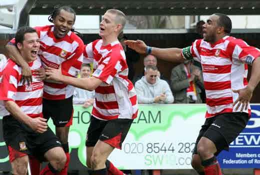 Teammates celebrate with goalscorer Bobby Traynor