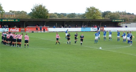 Kingstonian and Kettering players stand in silent tribute